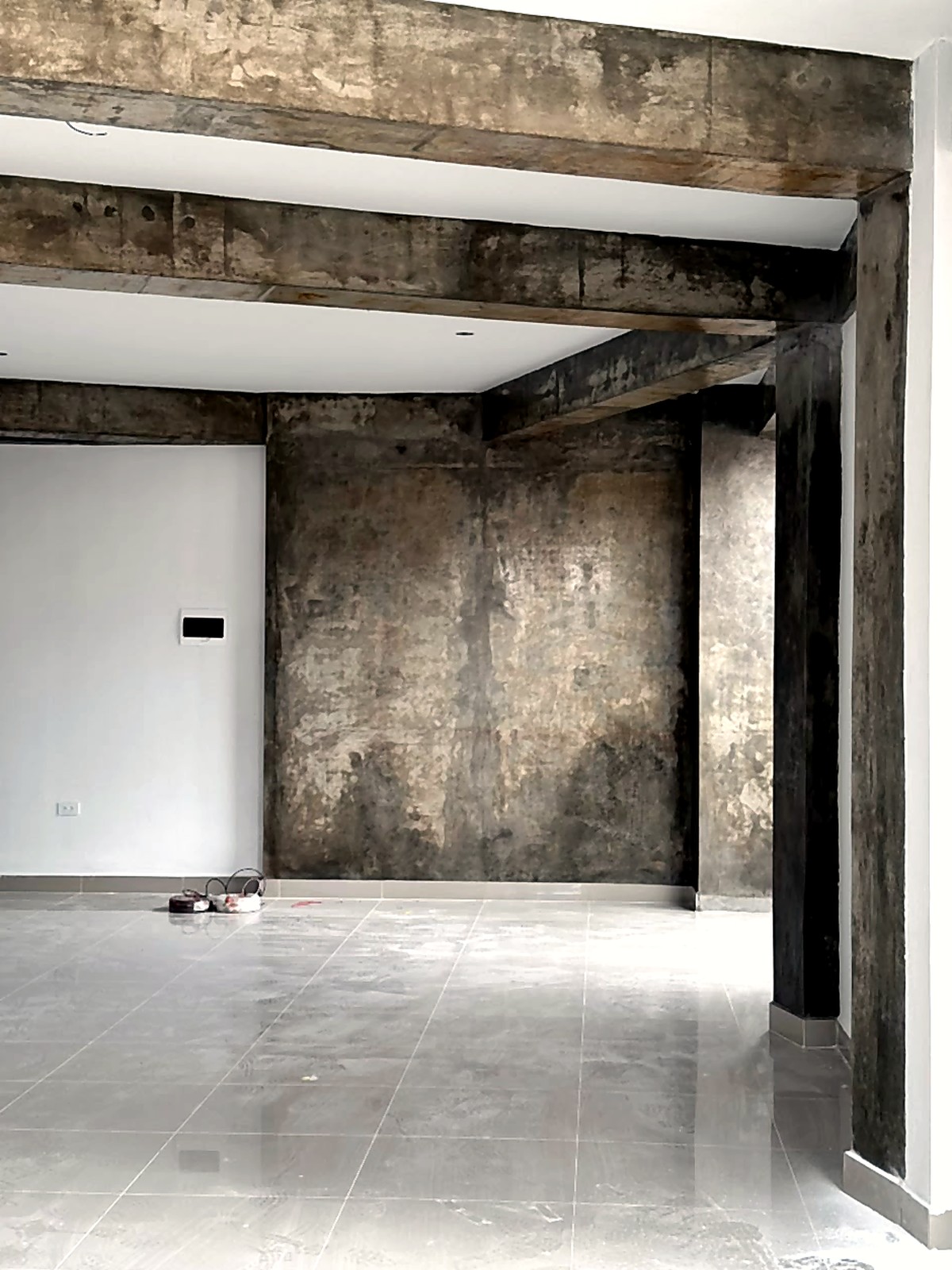 Interior de obra con vigas expuestas y piso en proceso